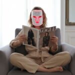 Which of Erikson Psychosocial Stages Are You In? Self-Assessment from a magazine while sitting on a sofa with beauty product on the female persons face