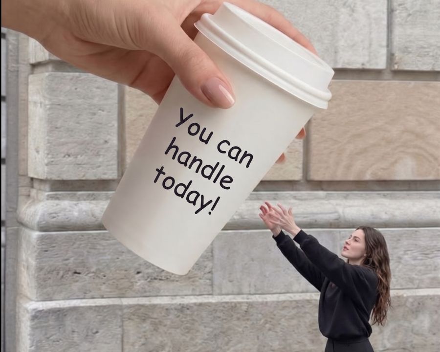 words of affirmation on a cup of coffee bigger than the woman standing in front a building trying to catch it